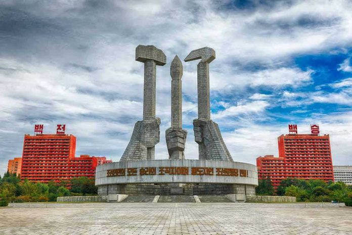 Concrete monument with hands holding tools under cloudy sky