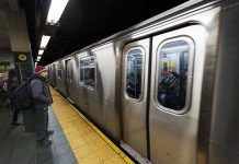 A commuter waiting at a subway station as a train approaches