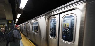 A commuter waiting at a subway station as a train approaches