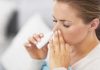 Woman applying nasal spray for relief