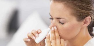 Woman applying nasal spray for relief