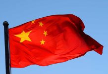 Chinese flag waving against a clear blue sky