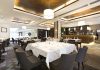 Interior of a modern restaurant with elegantly set tables and a bar area