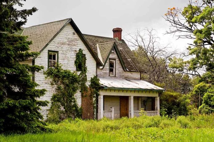 shutterstock_32440825.jpg An abandoned house surrounded by overgrown grass and trees