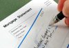 A person writing a check on a mortgage statement