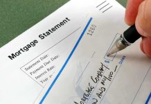 A person writing a check on a mortgage statement