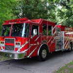 A red fire truck parked in a green park