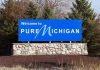 Welcome sign for Pure Michigan with a blue background and stone base