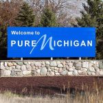 Welcome sign for Pure Michigan with a blue background and stone base