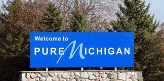 Welcome sign for Pure Michigan with a blue background and stone base