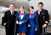 Group of airline crew members posing together at an airport