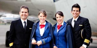 Group of airline crew members posing together at an airport