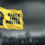 Yellow Black Lives Matter flag with clenched fist.