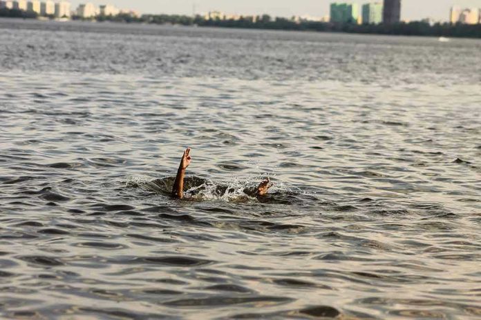 1828334342 Persons hand reaching out from the water.