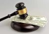 Gavel resting on hundred-dollar bills.