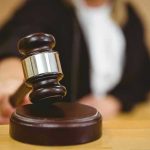 Judge striking gavel in a courtroom.