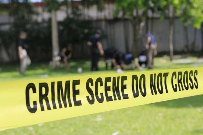 Yellow crime scene tape blocking grassy area.