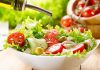 Fresh salad being drizzled with olive oil