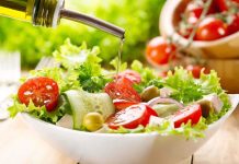 Fresh salad being drizzled with olive oil