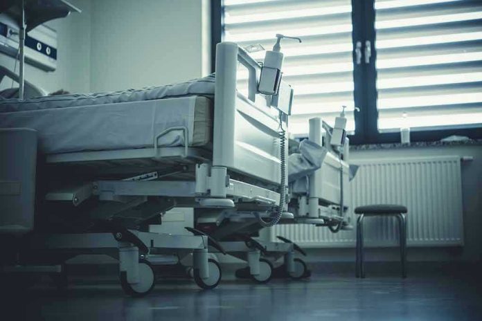 2292007351 Empty hospital beds by a window.