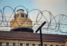 UNPRECEDENTED Gunfire – Federal Prison LOCKDOWN! Barbed wire in front of a prison tower.