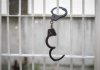 Handcuffs hanging on white metal bars
