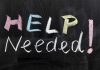 Help Needed written in colorful chalk.