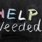 Help Needed written in colorful chalk.