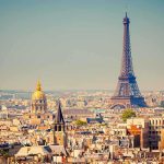 Prime Ministers DAYS NUMBERED – No Confidence Vote! A panoramic view of Paris featuring the Eiffel Tower and a golden dome