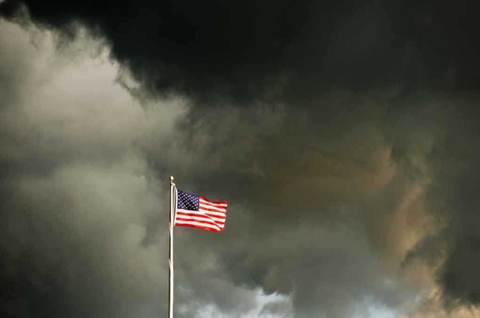 shutterstock_18914410.jpg American flag waving against a dark, stormy sky