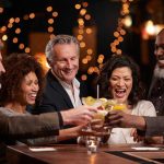 Boss DRUGGED Women With Mystery Cocktail People laughing while clinking glasses at a bar