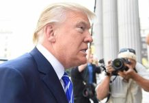 Ambassador’s Spy Meeting IGNITES MAGA Civil War Man in suit with photographers in background.