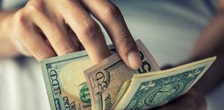 Person holding multiple US dollar bills