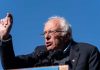 Sanders BLASTS Schumer and Party – Nobody Saw This Coming! A speaker passionately addressing a crowd at an outdoor rally