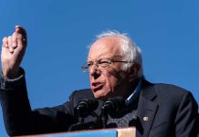 Sanders BLASTS Schumer and Party – Nobody Saw This Coming! A speaker passionately addressing a crowd at an outdoor rally
