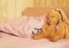 11-Year-Old Forced to Share Bed Sparks Uproar A cozy bedroom scene featuring a stuffed bunny and pink bedding