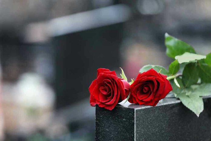 Two red roses on a gravestone.