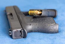 Handgun on blue fabric with visible bullet cartridge.