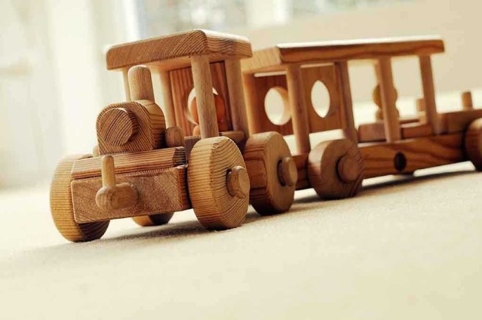 shutterstock_104172818.jpg A wooden toy train set on a carpeted surface