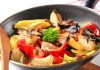 A skillet filled with colorful stir-fried vegetables including onions and bell peppers