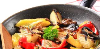 A skillet filled with colorful stir-fried vegetables including onions and bell peppers