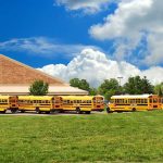 School Protects Perverts — Expelled Girl FIGHTS BACK A row of yellow school buses parked in front of a school building under a cloudy sky