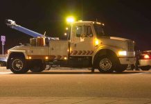Tow truck with flashing lights parked at night