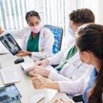 Doctors discussing chest X-ray results at a workstation.