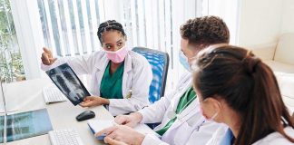 Doctors discussing chest X-ray results at a workstation.