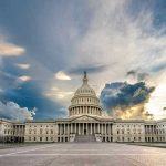 U.S. Capitol building with dramatic cloudy sky.