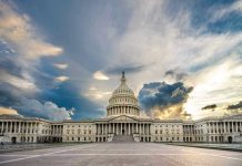 U.S. Capitol building with dramatic cloudy sky.