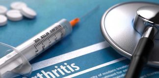 Syringe and stethoscope on arthritis document