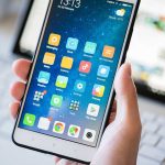 A person holding a smartphone displaying various mobile applications