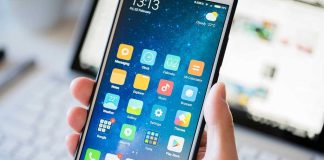 A person holding a smartphone displaying various mobile applications